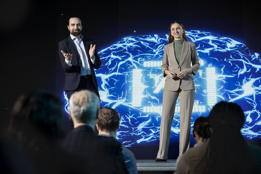 Two presenters hosting pitch presentation with ai